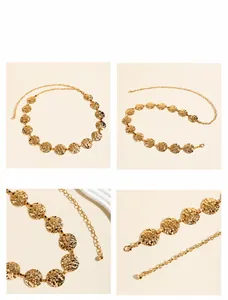 Detail van gouden metalen tailleketting met golvende ronde schijven en kreeftensluiting
