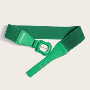 Detail of emerald green elastic waist belt with faux leather buckle and silver pin
