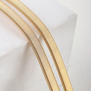 Macro shot of gold elastic metal belt showing detailed ring-link texture and high gloss finish
