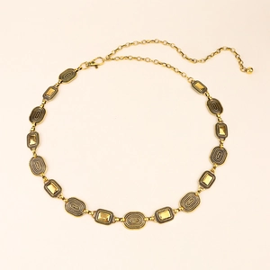 Close-up of golden metal waist chain with textured oval links and adjustable lobster clasp