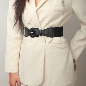 Detail of black elastic wide waist belt with wave edge PU leather on white blazer