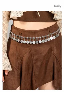 Detail van de bohemien zilveren metalen tailleketting met muntjes op kleding gedragen