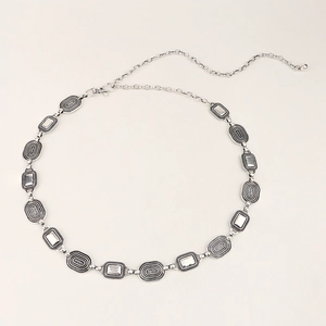 Detailed macro view of vintage silver metal waist chain with embossed oval geometric links