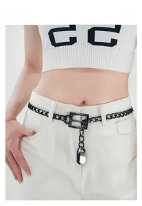 Detail of minimalist black metal waist chain with square buckle and rectangular lock pendant
