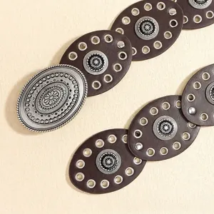 Detail of bohemian punk waist belt featuring vintage silver buckles and brown oval leather pieces