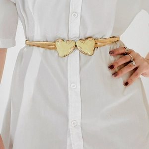 Fashionable gold metal spring waist chain featuring a heart-shaped buckle on a white shirt