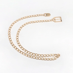 Detailed macro view of a glossy gold metal link chain belt with a square pin buckle design