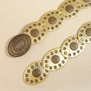 Detailed close-up of Bohemian metal belt with starburst relief and oval hollowed patterns