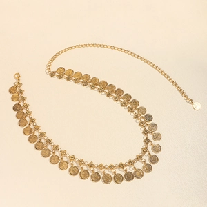 Detail van gouden tailleketting met reliëf munt hangers en verstelbare karabijnsluiting