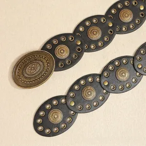 Detail of bohemian belt with vintage bronze sunburst buckle and black leather pieces