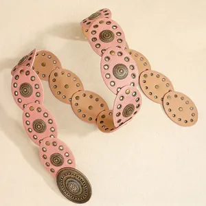 Detail view of Bohemian punk waist belt with engraved metal medallions and pink faux leather