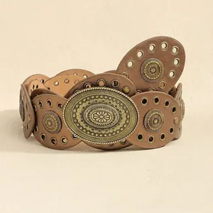 Close-up of bohemian brown leather belt with bronze oval buckle and sun rivets