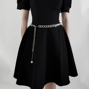 Ceinture chaîne en métal argenté pour femme avec pendentif étoile sur robe noire