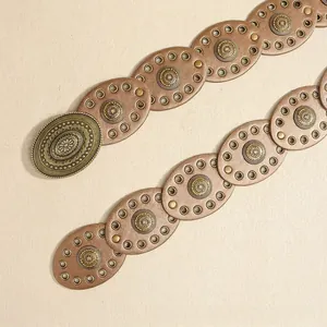 Detail of bohemian belt with vintage gold floral buckle and studded leather ovals