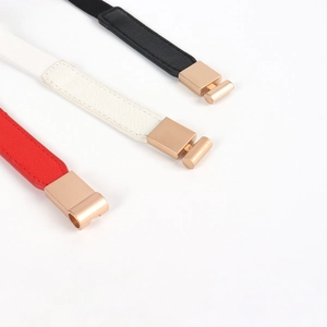 Three minimalist slim waist belts in red, white, and black with shiny gold metal buckles