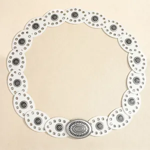 Detail view of white Bohemian belt with silver vintage buckle and metallic eyelets