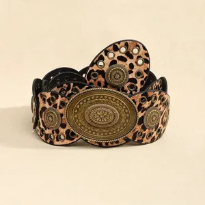 Detail of bohemian leopard print leather belt with large embossed bronze floral buckle
