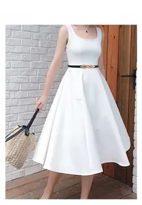 Detail of elegant gold leaf buckle on a thin black belt paired with a white dress