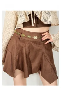 Detail of vintage carved gold metal chain belt on brown suede asymmetrical skirt