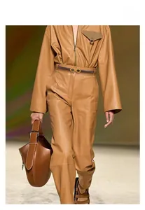 Détail d'une tenue en cuir beige avec un grand sac à main de créateur assorti