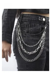 Détail d'une chaîne de pantalon multicouche en métal argenté avec crochets sur jean noir