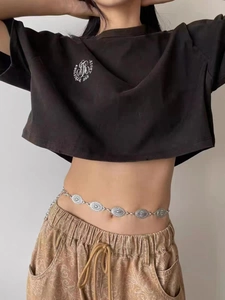 Detailed close-up of retro engraved silver metal waist chain with bohemian oval patterns
