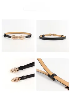Detailed close-up of slim black waist belt featuring gold leaf metal buckle and fine texture