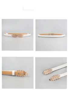Detail of white PU leather waist belt featuring a matte gold double leaf metal buckle