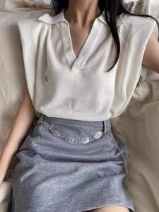 Detail showing vintage silver carved chain belt on a grey skirt with cream polo top