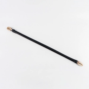 Detail of elegant gold leaf buckle and thin black leather waist belt on white background