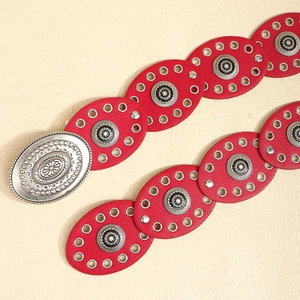 Close-up of red western leather belt featuring silver buckle and engraved metal buckles