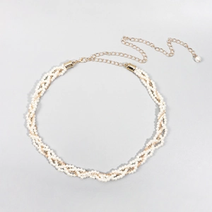 Dettaglio dell'elegante catena in vita con perle e chiusura dorata con pendente perla