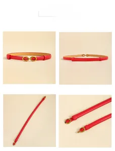Détail d'une ceinture fine en cuir rouge avec boucle métallique dorée et couture précise
