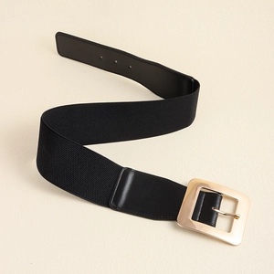 Détail de la ceinture élastique noire avec une boucle carrée en métal doré de luxe