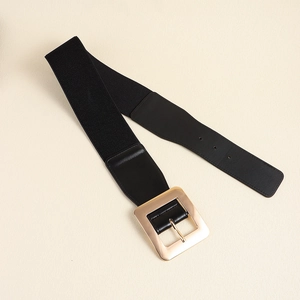 Détail d'une large ceinture élastique noire avec une grande boucle carrée en métal doré