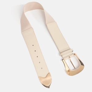 Detalle de cinturón elástico beige con hebilla en D dorada y punta metálica con forma de corazón