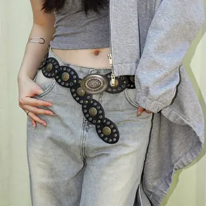 Detail of bohemian black leather belt with vintage hollow metal discs and large buckle