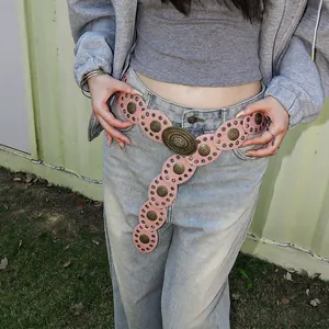 Detail of pink bohemian leather belt with vintage bronze circular metal floral studs