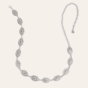 Macro detail of vintage silver belt chain featuring oval engraved pendants and lobster clasp