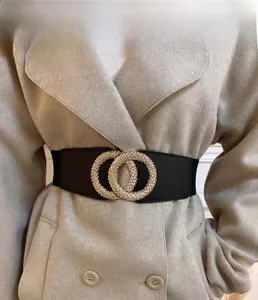 Close-up of golden interlocking double-ring buckle on a black wide elastic belt
