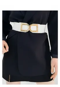 Détail de ceinture élastique blanche avec boucle dorée en D sur un costume sombre