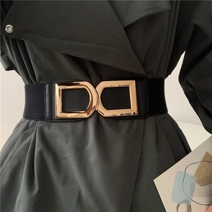 Détail de la boucle double D dorée sur ceinture élastique noire pour robe femme
