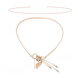 Detail of golden elastic waist belt featuring a crystal fox buckle with teardrop tassels