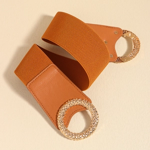 Detail of camel elastic belt with round gold buckle and textured leather accents