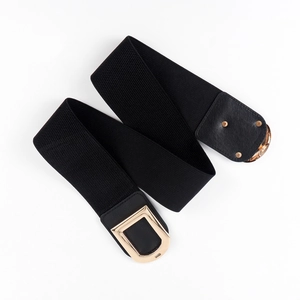 Détail d'une ceinture élastique noire avec boucle dorée en D et finition simili cuir