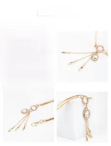 Detail of gold metal waist chain featuring crystal pendant and elegant tassel fringe