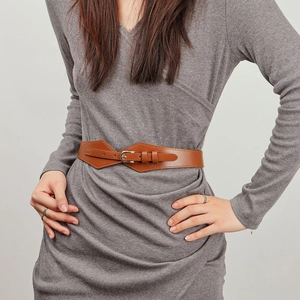 Detail showing high-waist brown leather belt with silver buckle on a gray knit dress