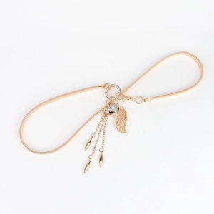 Detail of gold elastic snake chain belt with crystal fox head buckle and metal tassels