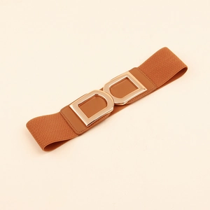 Détail d'une large ceinture élastique marron avec boucle double D en métal doré poli