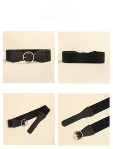 Detail view of black elastic wide waist belt with golden round buckle for women